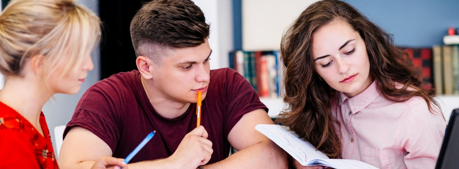 Three students at one table during a group English lesson